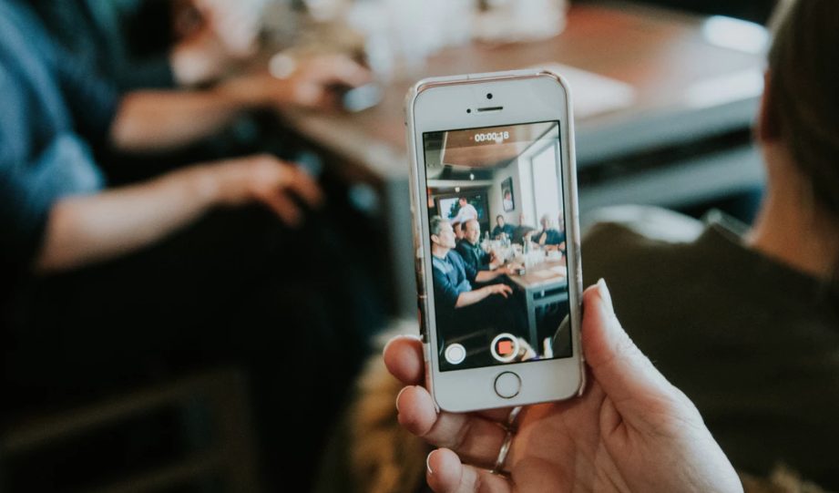 phone video recording man at table.