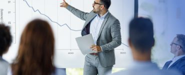 Man pointing to decreasing chart due to recession